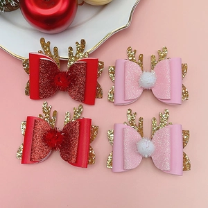 Detailed view of Christmas reindeer antler hair clips with glitter bows and plush balls