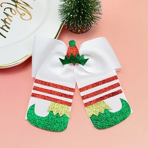 Detail of Christmas elf hat and glittery boots bow clip for girls on festive background