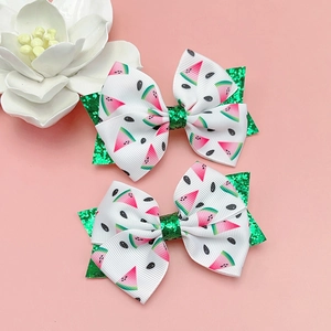 Détail de pinces à cheveux pastèque à paillettes avec des nœuds roses et verts
