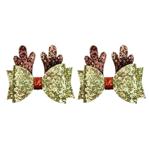 Close-up of glittery Christmas hair clips featuring reindeer antlers and red bows
