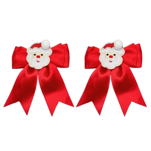 Detailed view of red satin Christmas hair bows with Santa Claus embroidery and V-cut tails