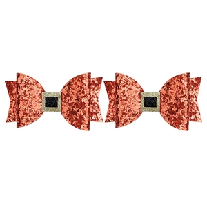 Detail of red glitter bow hair clips with gold buckle and festive holiday design