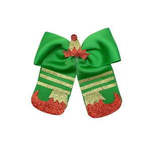 Detail of festive elf hair bow with green ribbon and sparkling red glitter boots