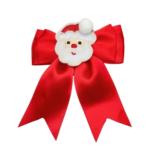 Detail of Christmas hair clip with red satin bow and embroidered Santa Claus patch
