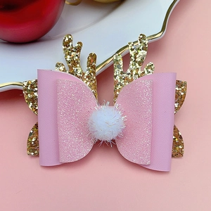 Detail of pink glitter Christmas reindeer hair clip with bow and white pom-pom