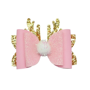 Detailed view of pink Christmas reindeer antler hair clip with bow and soft pom pom