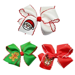 Close-up of Christmas ribbon hair clips with Santa, gingerbread, and reindeer embroidery