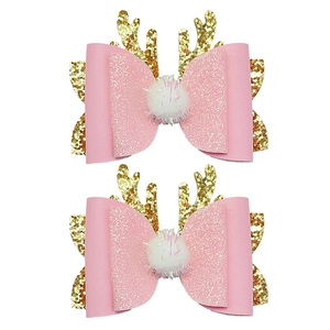 Detail of pink leather hair clips with golden glitter reindeer antlers and pom poms