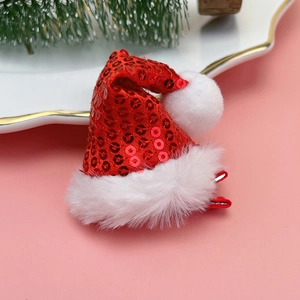 Close-up of red sequin Christmas hat hair clip with white plush trim on pink background