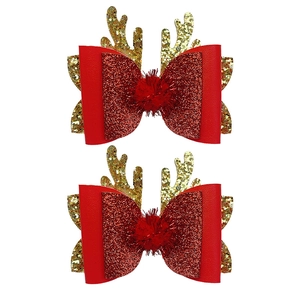 Detail of red Christmas bow hair clips with gold reindeer antlers and soft pom-poms