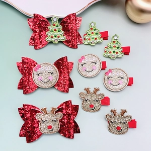 Close-up of Christmas hair clip set featuring glitter bows with gingerbread and reindeer icons