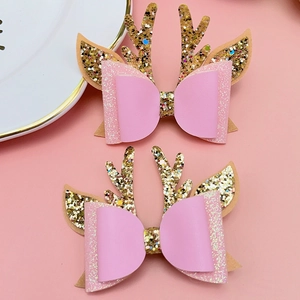 Detailansicht der Glitzer-Rentiergeweihe und rosa Schleifenclips für festlichen Haarschmuck