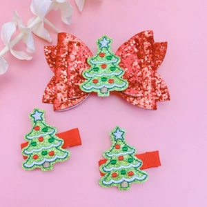 Detail of Christmas hair clip set featuring sequins bow and embroidered green tree patches