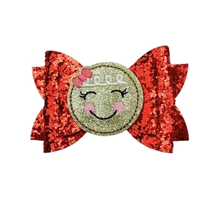 Detailed view of children's Christmas hair clip with red sequins and a smiling face patch