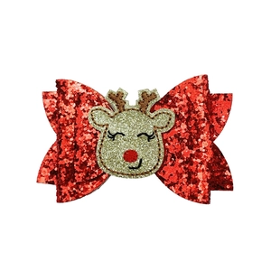 Detail of red sequined Christmas bow hair clip featuring a 3D reindeer embroidery element