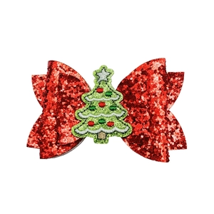 Close-up of red sequin bow hair clip featuring detailed Christmas tree embroidery