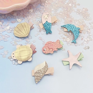 Detail of seven ocean-themed children's hair clips with glitter leather and sea animal shapes