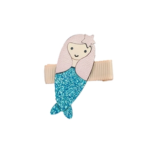 Detail of mermaid hair clip with pink leather top and blue glitter fin on beige ribbon