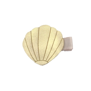Detailed close-up of shell-shaped champagne gold PU leather hair clip with pink ribbon base