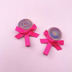 Detail view of handmade lollipop hair clips with rainbow ribbon spirals and pink bows
