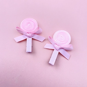 Detailed view of handmade pink ribbon lollipop hair clips for girls with cute bow accents