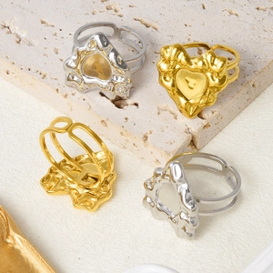 Macro detail of gold and silver heart-shaped irregular rings on beige stone background