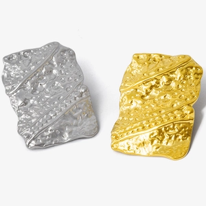 Detailed macro view of 18K gold and silver plated irregular geometric steel earrings