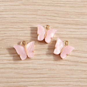 Nahaufnahme von rosa Schmetterlingsanhängern mit Goldlegierung für Schmuckzubehör