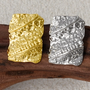 Detailed macro view of 18K gold and silver plated irregular lava texture earrings