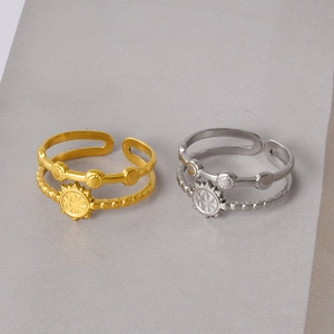 Detail showing dual-layer stainless steel rings with bohemian sun motif in gold and silver