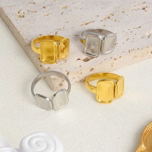 Detailed view of square geometric matte rings in gold and silver on stone