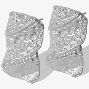 Detailed macro view of silver geometric 304 stainless steel earrings with irregular texture