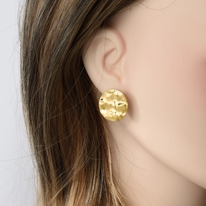Golden 304 stainless steel oval earrings with unique hammered texture on female model
