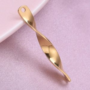 Macro shot of gold-plated spiral twist pendant on soft purple and pink fabric