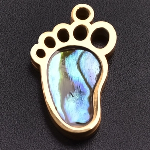 Macro detail of a 304 stainless steel paw pendant with iridescent rainbow shell inlay