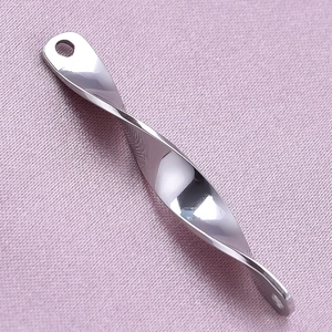 Macro detail of polished 304 stainless steel twisted pendant with silver mirror finish