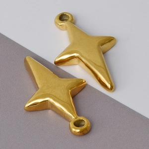 Macro shot of two polished gold-plated stainless steel star pendants for DIY jewelry