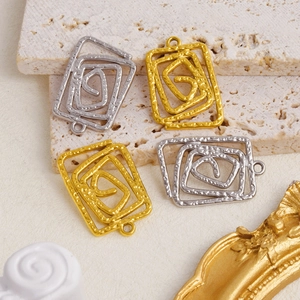 Gros plan de pendentifs spirale en or 18K et argent avec texture martelée sur pierre