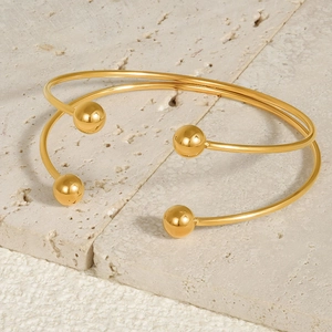 Detailed macro view of 18k gold-plated 304 stainless steel open bangles on stone