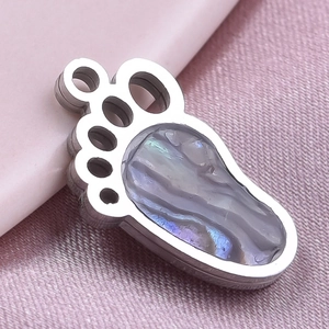Detailed macro view of 304 stainless steel paw pendant with iridescent abalone shell inlay