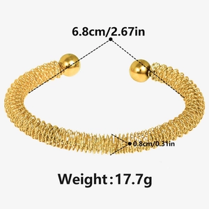 Detail view of gold mesh coil bracelet with size specs and smooth metal ball ends