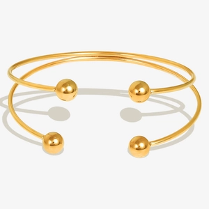 Set of two minimalist 18k gold plated stainless steel cuff bracelets with spherical ends
