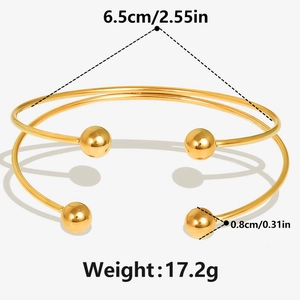 Detail view of 18k gold double-loop bangle with 6.5cm diameter and metal ball ends