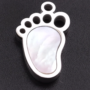 Macro detail of 304 stainless steel paw pendant with white mother of pearl inlay