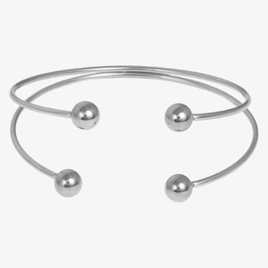 Detailed macro view of silver minimalist double-layered open cuff with spherical ends