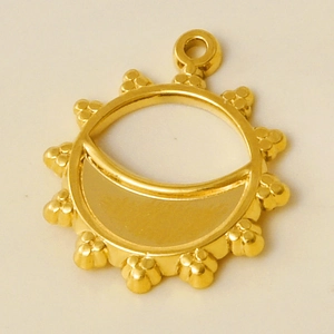 Macro shot of gold sunburst hollow pendant with crescent base for DIY jewelry making