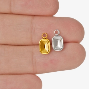 Makroaufnahme goldener und silberner rechteckiger Anhängerfassungen für DIY-Schmuck