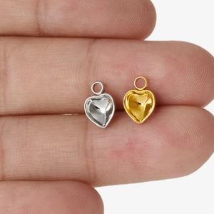 Makroaufnahme von Gold- und Silber-Herzanhängern zur Darstellung der Mini-Größe für DIY