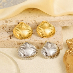 Détail macro de boucles d'oreilles coquillage or et argent aux textures verticales