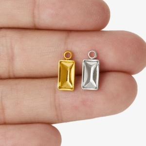 Makroansicht goldener und silberner rechteckiger Anhänger für DIY-Schmuck